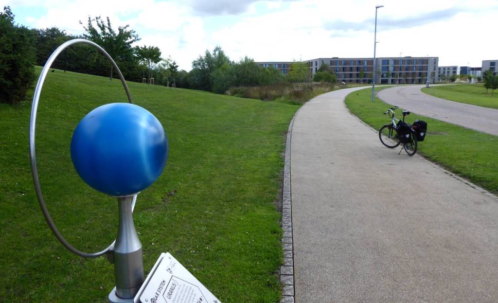 A scale model of Uranus with university buildings in the background
