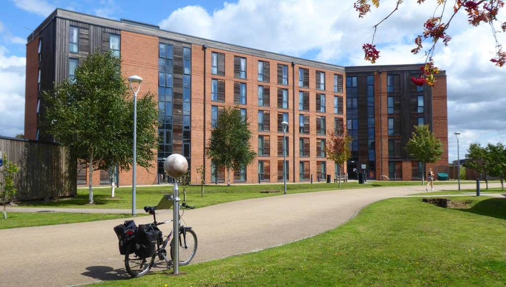 A scale model of Pluto with a university building behind