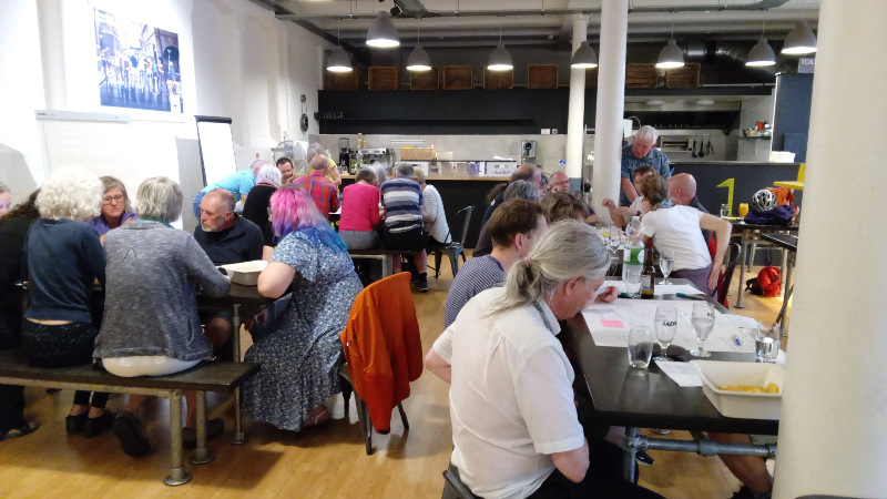 Several groups of people sat around tables in discussion