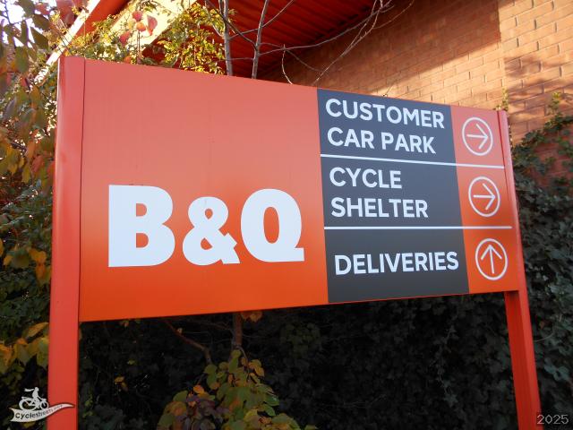Sign for B&Q indicating directions to customer car park, cycle shelter, and deliveries.